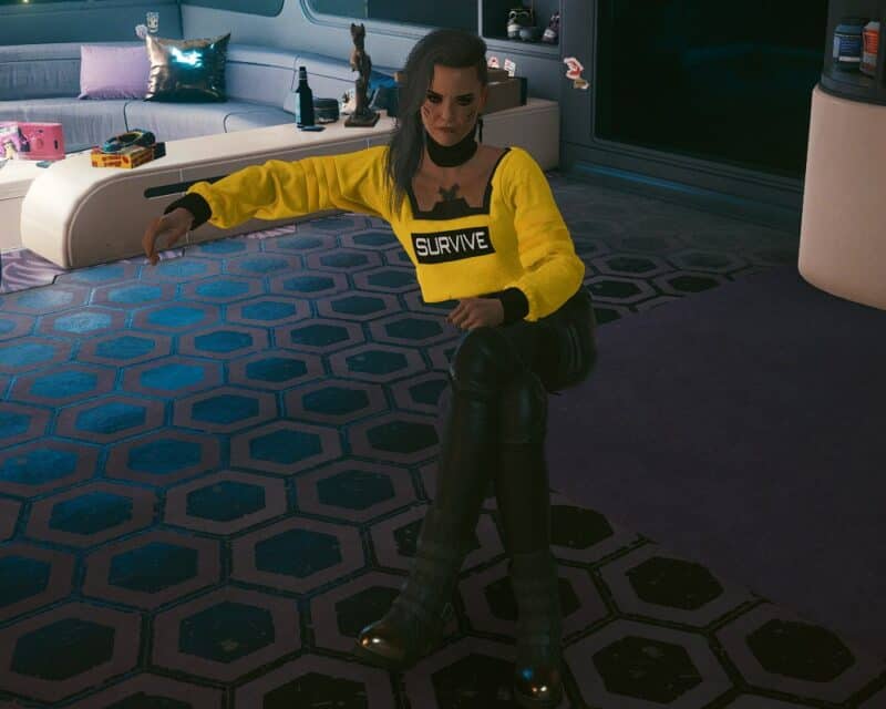 Screen z gry Cyberpunk 2077 - Rogue Amendiares, właścicielka słynnego klubu nocnego Afterlife, siedzi na niewidzialnej kanapie w mieszkaniu V