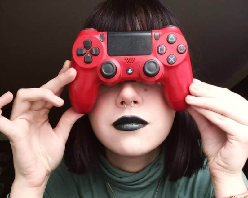 dyskryminacja kobiet w grach online, dziewczyna z czerwonym padem trzymanym na wysokości oczu