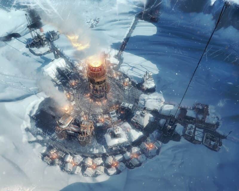 Frostpunk za darmo, na obrazku osada w dolinie z działającym generatorem i śniegiem wokół