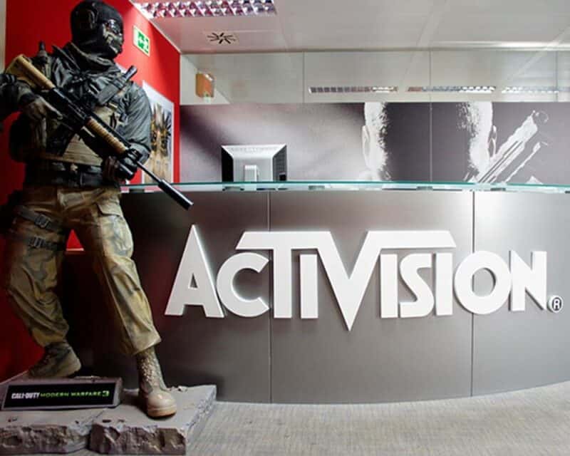 Protest pracowników Activision Blizzard, na pierwszym planie biurko z napisem Activision, po lewej figurka postaci z gry, w tle ściana