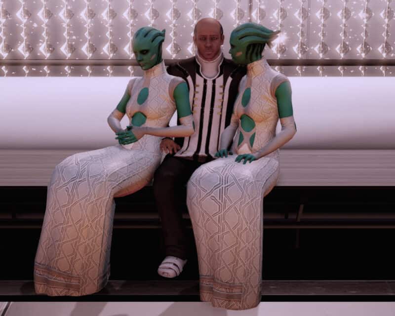 Sukces Mass Effect: Legendary Edition - obrazek przedstawia dobrze ubranego mężczyznę, któremu towarzyszą dwie piękne Asari