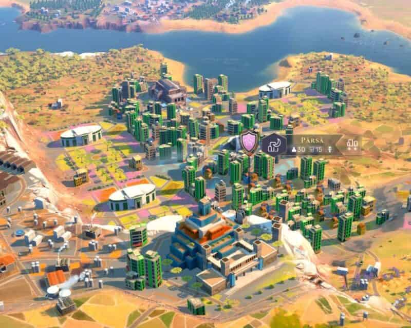 Budynki w Humankind, widok z lotu ptaka na miasteczko z terenami leśnymi i jeziorem u góry ekranu