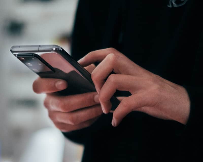 Ray tracing w smartfonie. Zdjęcie przedstawia ręce trzymające nowoczesny telefon.