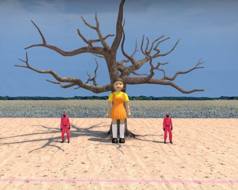 Screen z gry CS:GO, mapa niestandardowa inspirowana Squid Game, na zdjęciu charakterystyczna duża lalka i dwóch ludzi w fuksjowych kostiumach, Squid Game nowa mapa CS GO