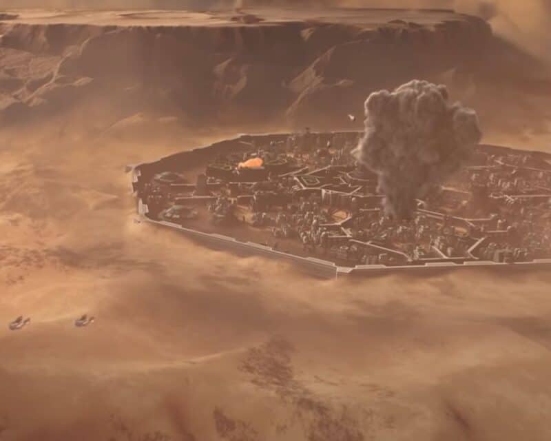 Grafika promująca nową grę w uniwersum Diuny, miasto znajdujące się w bezpiecznej części Arrakis jest atakowane i płonie, w tle lecące w jedną i drugą stronę statki kosmiczne, TGA 2021 Dune Spice Wars zapowiedź