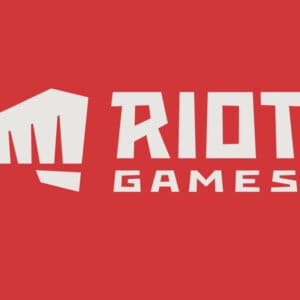 Riot Games zapłaci karę za dyskryminację kobiet. Na obrazku nowe logo firmy. Zaciśnieta pięść wymierzająca cios i nazwa studia na czerwonym tle.