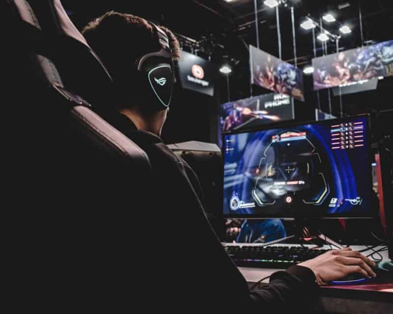 zdjęcie przedstawiające mężczyznę siedzącego na krześle gamingowym podczas turnieju esportowego, siedzi tyłem i gra, E-sport polscy gracze zarobki