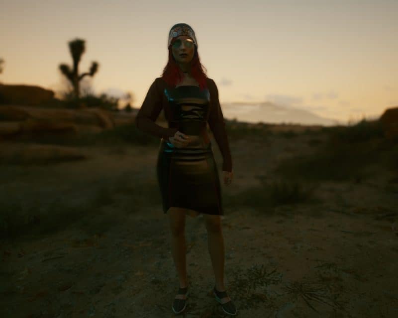 Jedna z postaci niezależnych w grze Cyberpunk 2077 wysyła nagie fotki – screen z gry, V w pięknym ubraniu na pustyni o zachodzie słońca