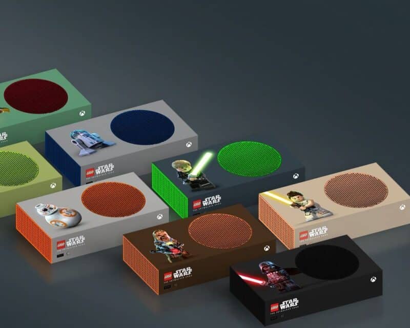 obrazek przedstawiający wybrane konsole przygotowane przez Microsoft z okazji Dnia Gwiezdnych Wojen: beżowa z ludzikiem LEGO w beżowym ubraniu i z żółtym mieczem, czarno-zielona z ludzikiem LEGO w czarnym ubraniu i blond włosach, z zielonym mieczem, Czarna z ludzikiem LEGO w czarnym ubraniu i hełmie, z czerwonym mieczem, brązowa z brązowym potworem na dwóch nogach podobnym do misia, szaro-pomarańczowa z okrągłym robocikiem i szaro-niebieska z robocikiem prostokątnym z półkolem na górze, Microsoft 12 konsol Xbox Dzień Gwiezdnych Wojen