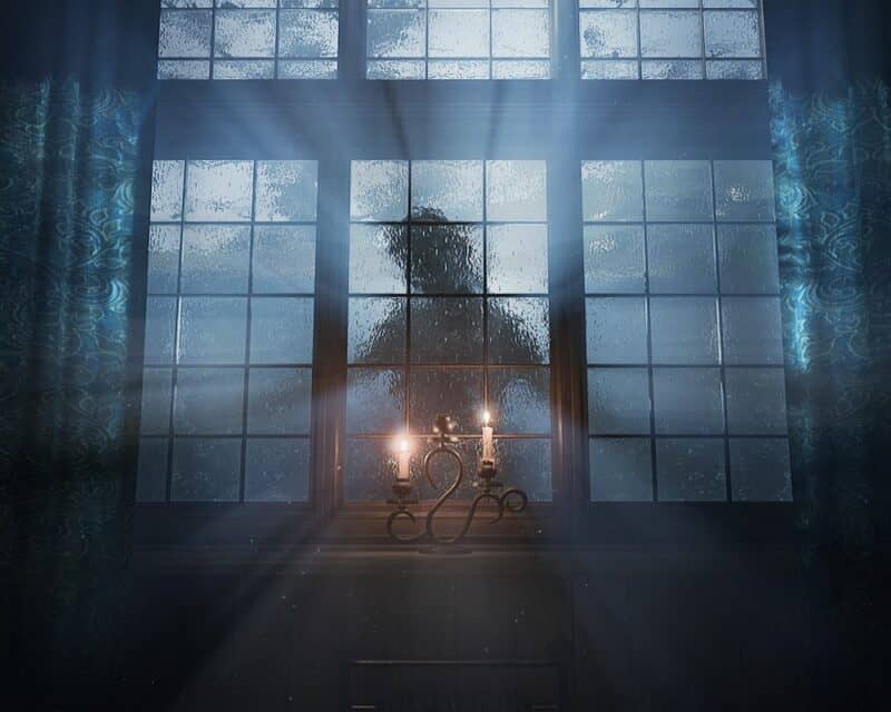 obrazek przedstawia cień tajemniczej postaci za oknem, emanuje z niej swiatło, przed nią, w pomieszczeniu, stoi świecznik z palącymi się świecami, screen z remastera Layers of Fear