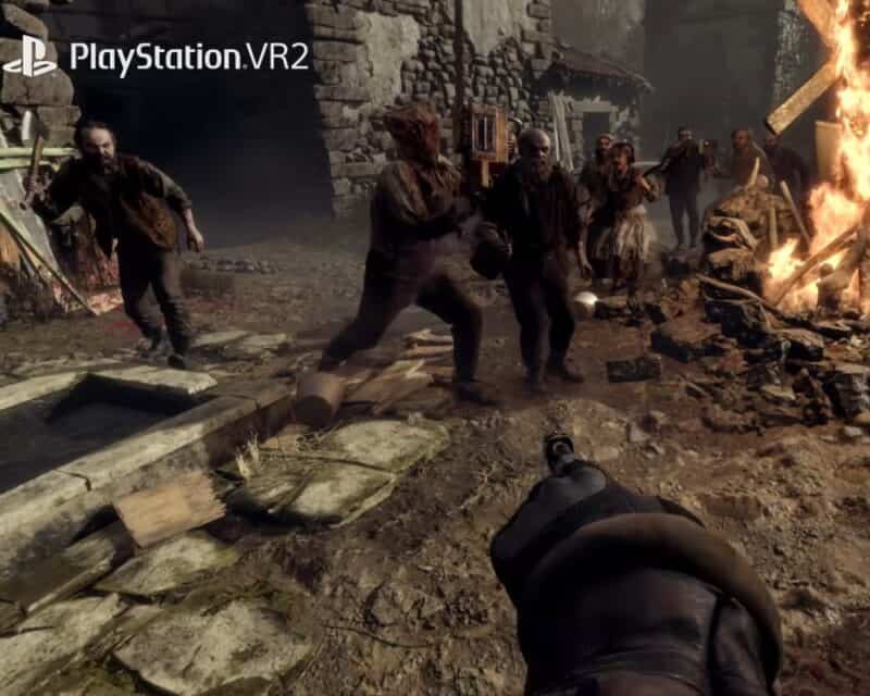 obrazek przedstawia podniszczoną wioskę w Hiszpanii, widać dłoń z pistoletem naszego protagonisty a przed nim wrogo nastawionych mieszkańców, jeden z nich trzyma piłę mechaniczną i ma na głowie worek