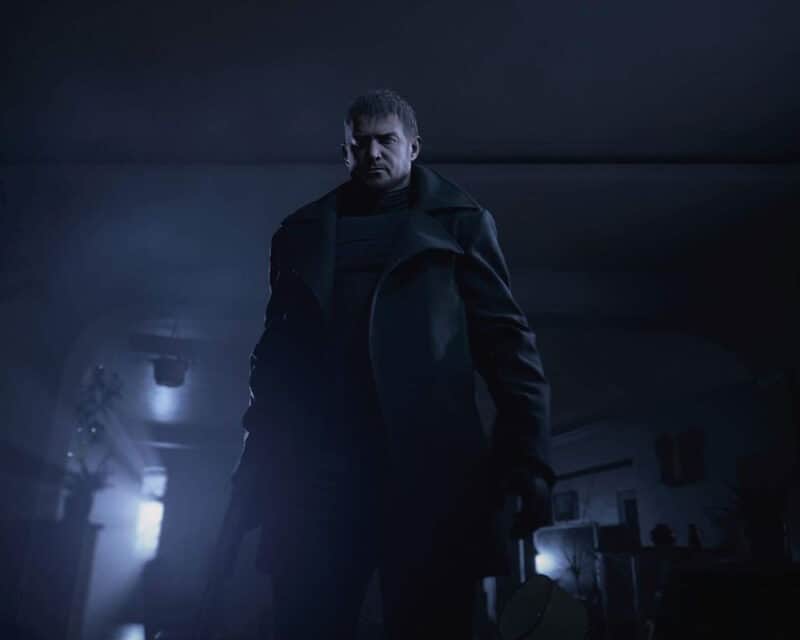 Obrazek przedstawia postać z serii Resident Evil, Chrisa Redfielda. Mężczyzna ubrany jest cały na czarno i znajduje się w ciemnym pomieszczeniu.