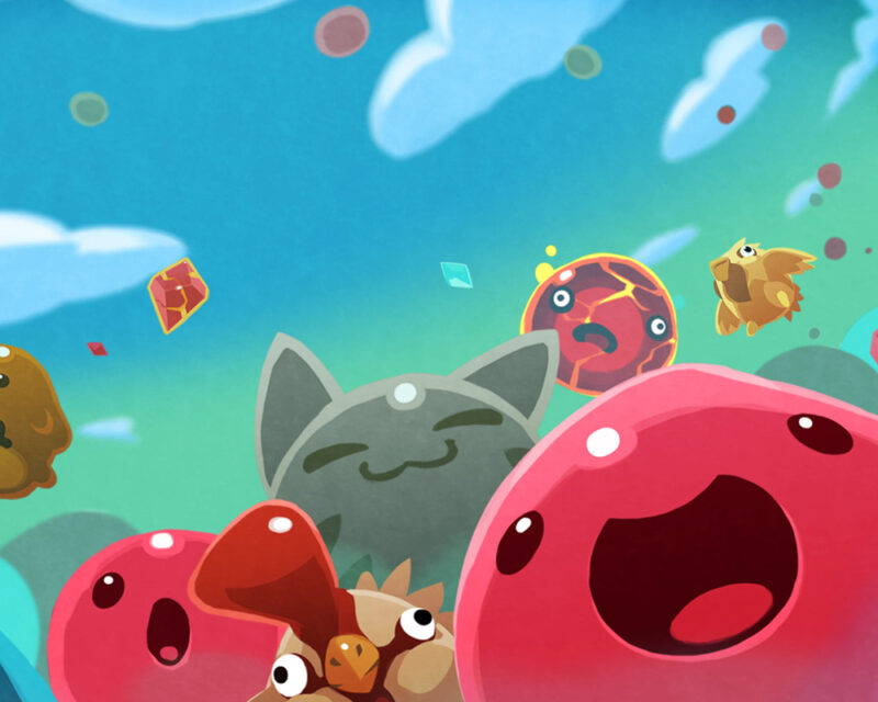 Obrazek przedstawia kolorowe stworki, znane jako slime’y, z gry Slime Rancher.