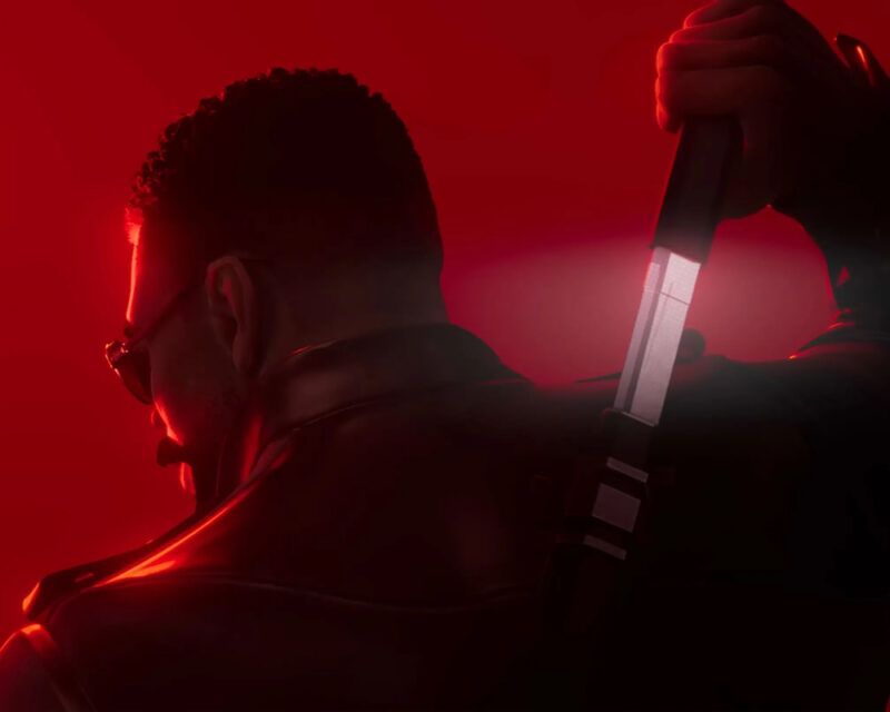 Obrazek przedstawia głównego bohatera gry Marvel’s Blade – Blade’a. Mężczyzna jest odwrócony i wyciąga zawieszony na plecach miecz. Ma na sobie czarny płaszcz i ciemne okulary.