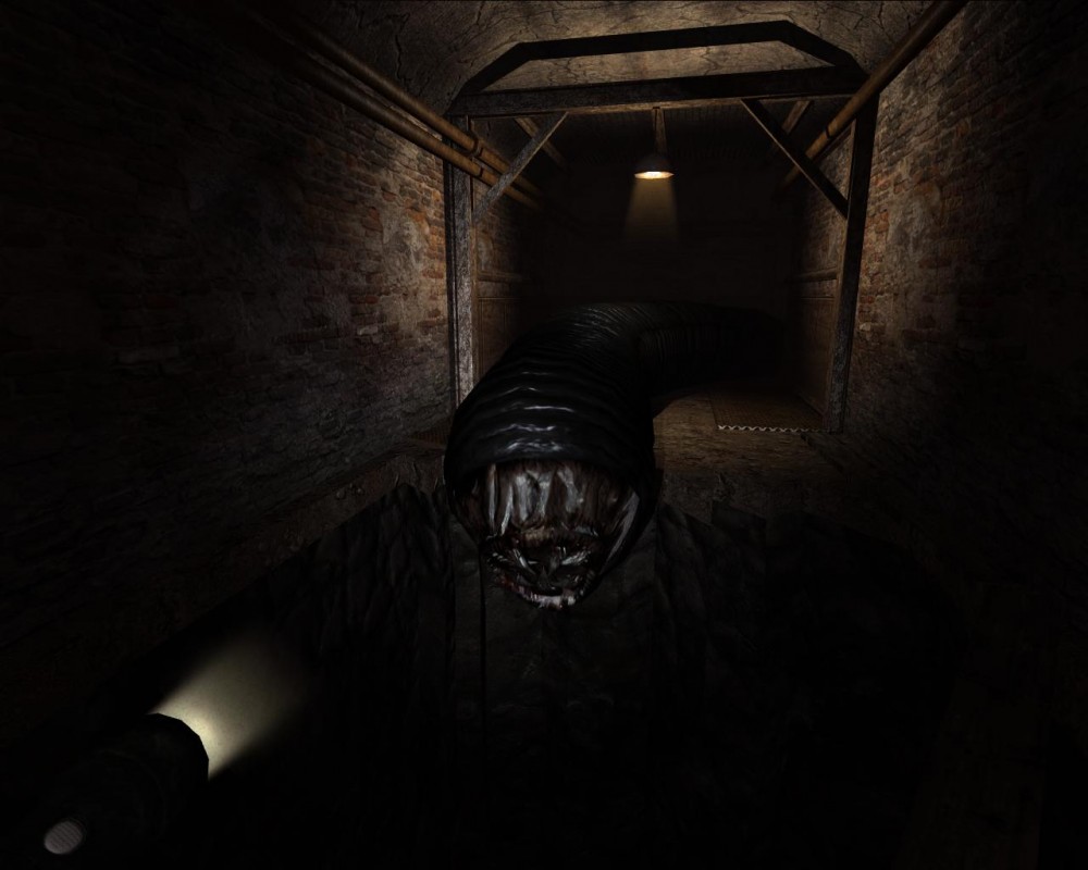 Na obrazku znajduje się zrzut ekranu z gry Penumbra: Overture, na którym w ciemnym podziemnym komentarzu widać potwora w postaci węża z wieloma ostrymi zębami