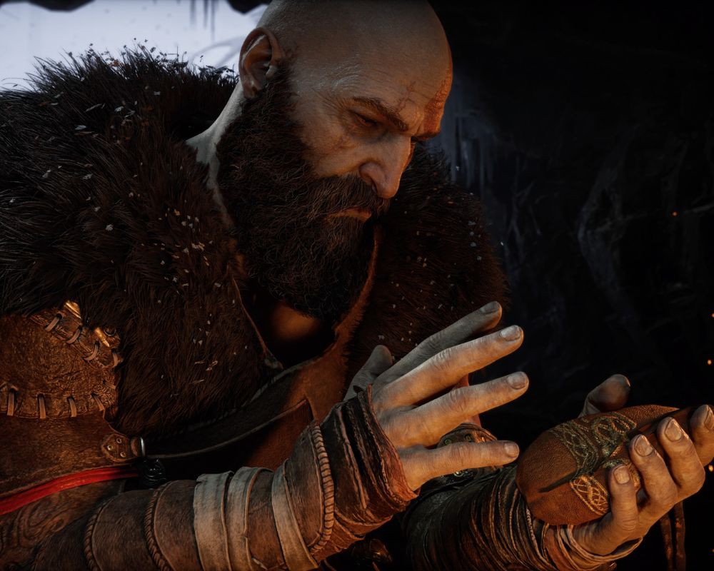 Kratos trzymający w rękach jakiś przedmiot