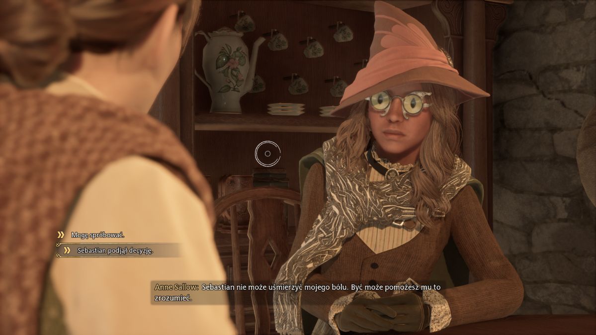 Hogwarts Legacy - na grafice widzimy kobietę siedzącą w różowym czarodziejskim kapeluszu, w zielonym płaszczu i z dziwnymi okularami na oczach