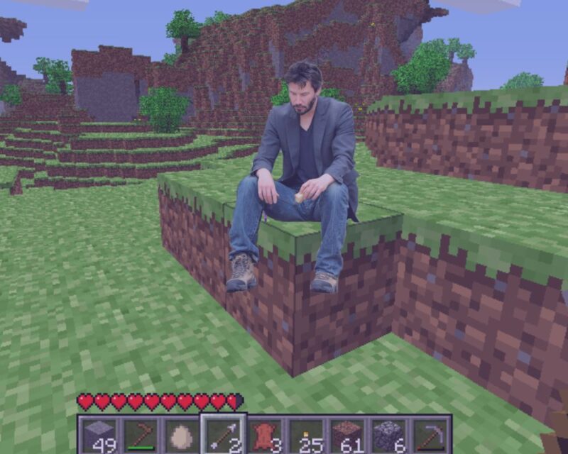 Zdjęcie z gry minecraft przedstawiające kilka bloków dirta, na których siedzi smutny Keanu Reeves