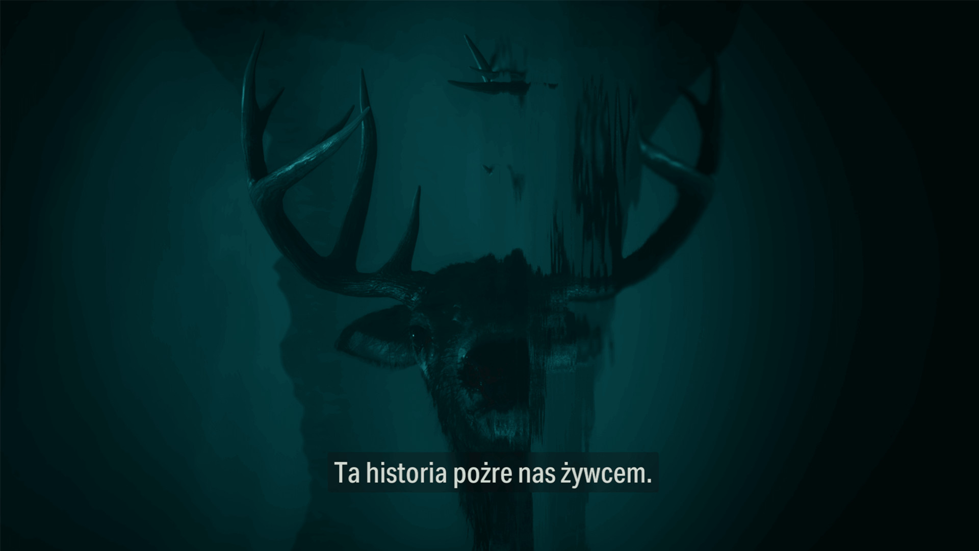 Zrzut ekranu z gry Alan Wake 2. Na obrazku widnieje głowa jelenia wyłaniająca się z wody. Pod spodem fragment dialogu: "ta historia pożre nas żywcem".