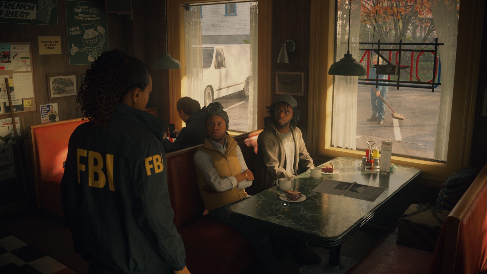 Zrzut ekranu z gry Alan Wake 2. Wnętrze restauracji. Z lewej strony stoi Saga Anderson, ubrana w kurtkę z napisem FBI. Przed nią przy stoliku siedzą dwie osoby, patrzą na nią uważnie.