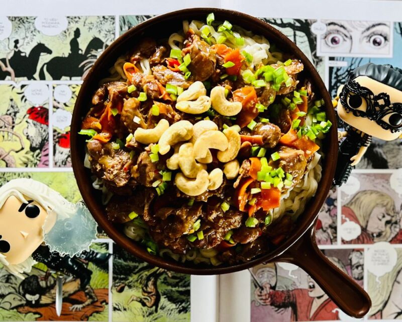 Na zdjęciu widać gulasz mięsny, nazwany gulaszem z sukkuba, inspirowany grą wiedźmin. Danie podane jest na patelni, obok leżą figurki postaci Geralta i Yennefer