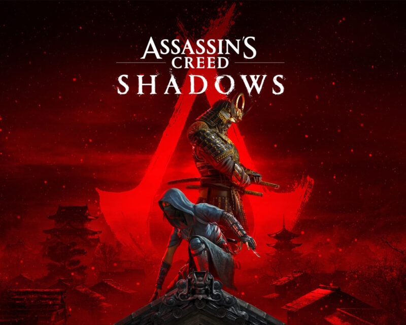 Grafika promująca grę Assassin’s Creed Shadows. W centrum obrazka, na dachu budynku, możemy zobaczyć dwójkę protagonistów – czarnoskórego samuraja, Yasuke i kobietę-shinobi, Naoe. Na czerwonym tle widać zarysy budowli w japońskim stylu.