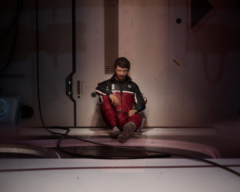 Demo The Alters – recenzja – Jan siedzący pod ścianą i patrzący pustym wzrokiem w kamerę