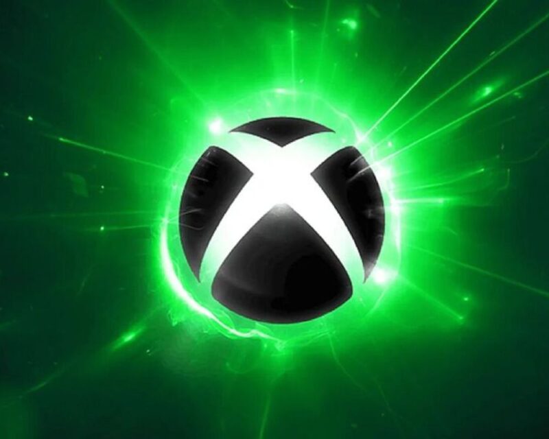 Xbox Games Showcase 2024, logo Xboxa z X na czarnej kuli/gałce, wokół kuli jasnozielone tło, w dali ciemnozielone