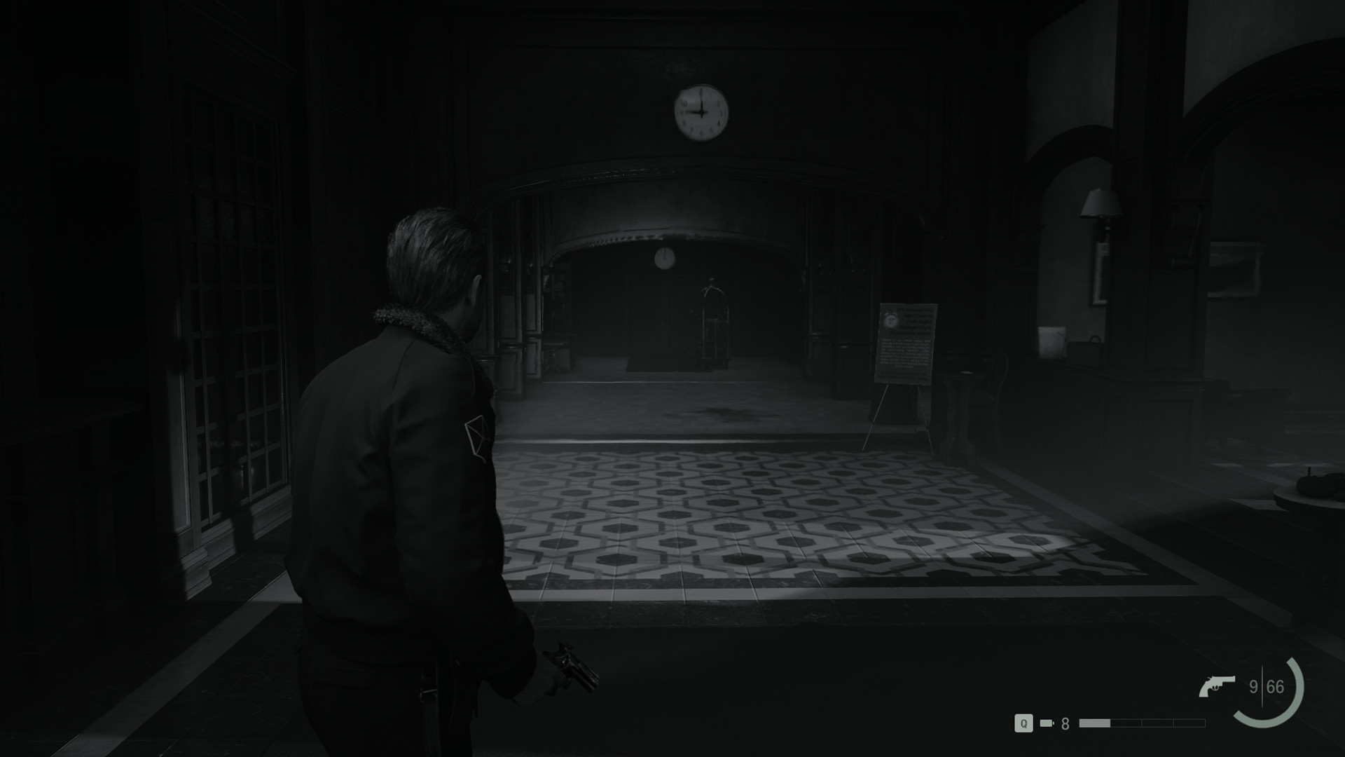 Zdjęcie jest czarno-białe, przedstawia mężczyznę idącego przez hol hotelowy.