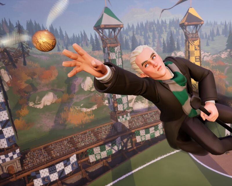 Harry Potter: Mistrzowie Quidditcha, na obrazku widzimy postac mężczyzny o krótkich blond włosach, siedzi na miotle i unosi się nad boiskiem do quidditcha, na grafice sięga ręką w kierunku znicza (latająca kulka ze skrzydełkami)