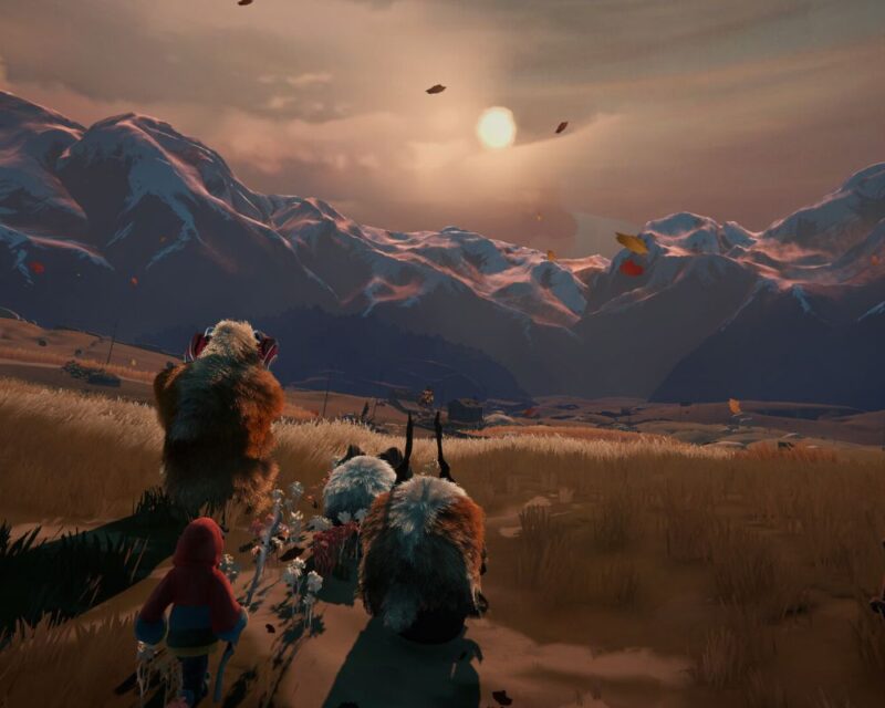 screenshot ze zwiastunu Herdling, widzimy górski krajobraz ze słońcem unoszącym się nad górskimi szczytami, na pierwszym planie zaś stoi ludzka postać zwrócona do nas tyłem i idzie w kierunku gór w oddali wraz ze stadem tajemniczych istot