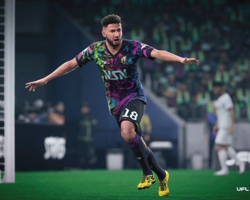 Piłkarz biegnący przez boisko z rękami podniesionymi do góry. Ma usta otwarte ze zdziwienia.