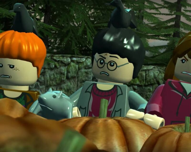 Dwaj chłopcy i dziewczyna chowają się za dyniami