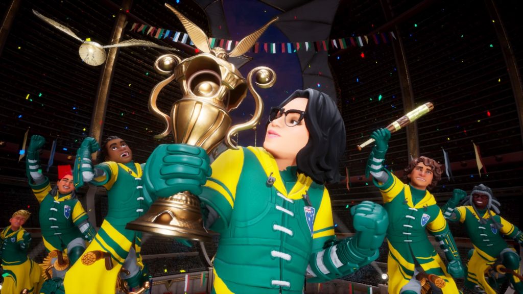 Grupa zawodników celebruje zwycięstwo w turnieju. Kobieta na pierwszym planie trzyma puchar, w tle ludzie wiwatują, jeden trzyma pałkę. Wszyscy wznoszą pięści do góry, w geście triumfu.