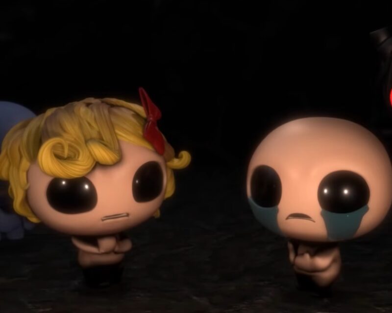 Grafika przedstawiająca bohaterów gry The Binding of Isaac: Rebirth, czyli Isaaca i Magdalene. Znajdują się w ciemnym pomieszczeniu w którym nie widać niczego poza nimi. Wyglądają na zmartwionych i mają smutny wyraz twarzy.