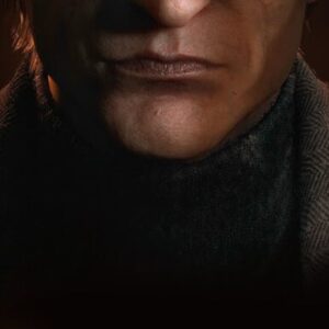 Screenshot ze zwiastuna gry Dying Light: The Beast z antagonistą, grafika jest ciemna, widzimy na niej zbliżenie na męską twarz, konkretnie na dół nosa i usta, pół twarzy ukryte jest w ciemności, a pół lekko oświetlone