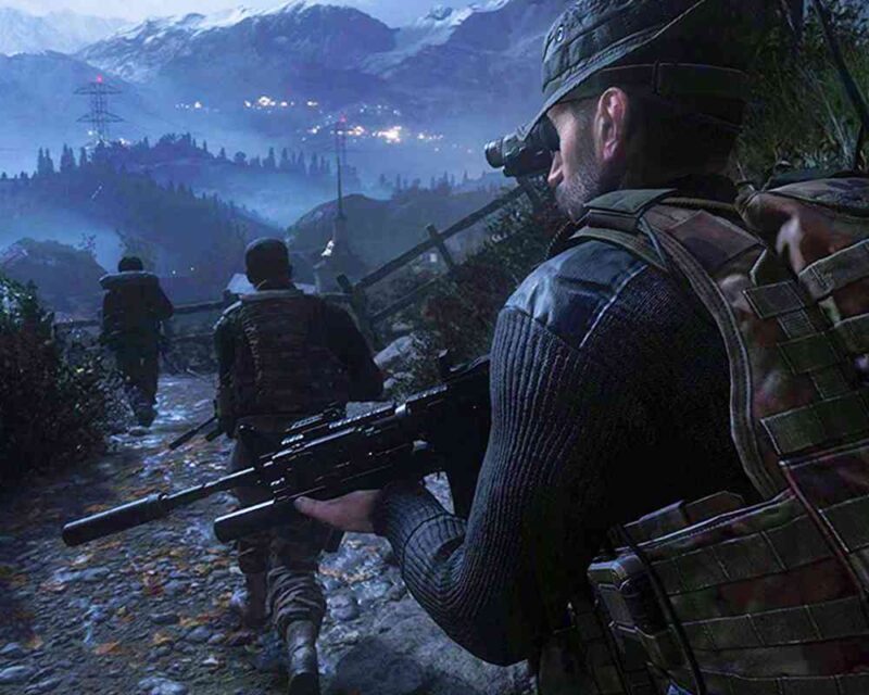 Grupa trzech żołnierzy w pełnym umundurowaniu, z bronią w rękach, porusza się nocą w górzystym terenie. Żołnierz na pierwszym planie, widziany od tyłu, trzyma karabin z tłumikiem i ma noktowizor na hełmie. W oddali widać światła osady lub bazy, a otoczenie jest oświetlone delikatnym blaskiem księżyca.