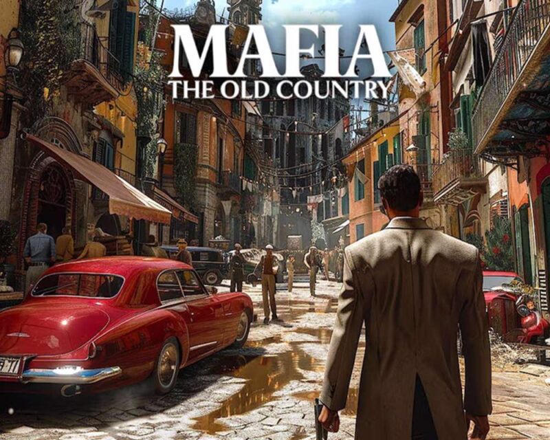 Scena z gry Mafia: The Old Country przedstawiająca wąską, włoską uliczkę z połowy XX wieku. Po lewej stronie stoi klasyczny czerwony samochód z tamtego okresu, a w tle widoczne są kolorowe kamienice z balkonami oraz rozwieszone pranie. Na ulicy widać grupki ludzi, a na pierwszym planie stoi mężczyzna w beżowym płaszczu, trzymający broń w prawej ręce i patrzący przed siebie.
