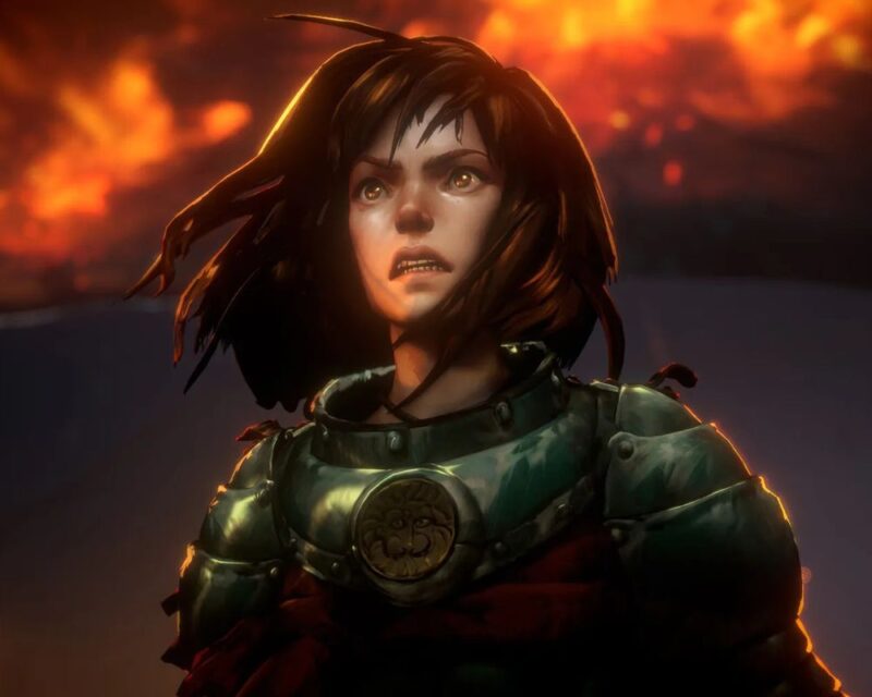 Obrazek przedstawia młodą kobietę w zbroi, z wyrazem determinacji i niepokoju na twarzy. Ma ciemne włosy rozwiane wiatrem, a jej zbroja lśni w świetle płomieni widocznych w tle.