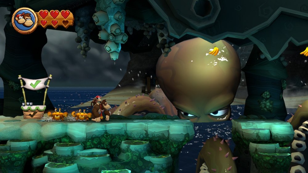 Donkey Kong niosący na plecach Diddy'ego Konga. W tle gigantyczna głowa ośmiornicy spoglądającej na bohaterów złowieszczym wzrokiem.