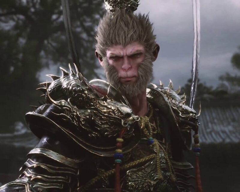 Obraz przedstawia głównego bohatera Black Myth: Wukong, postać o małpiej twarzy, w zdobionej zbroi, otoczonego mrocznym, mglistym tłem.
