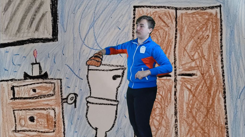 Mężczyzna wyjmuje coś z toalety. W tle narysowana łazienka - szafka, toaleta, świeczka.