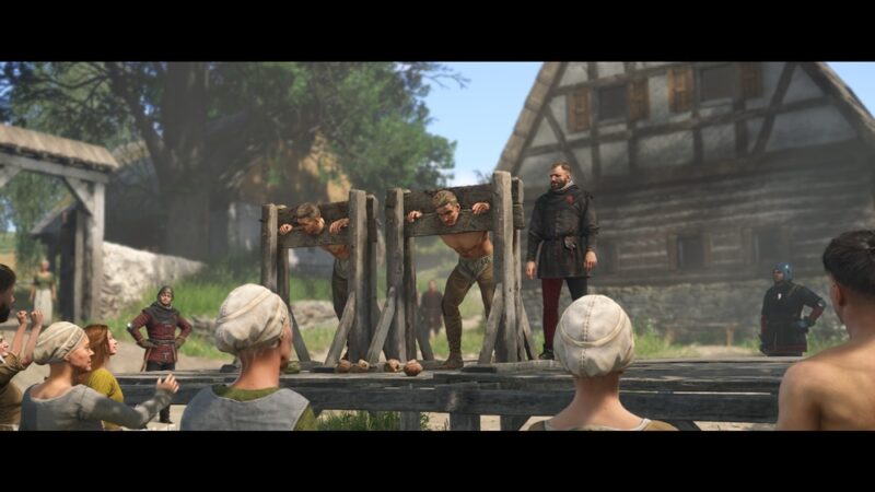 Na środku dwóch mężczyzn w dybach i mężczyzna pilnujący ich. Dookoła tłum gapiów, w tle wioska