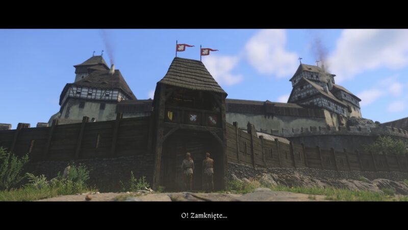 Twierdza, u bram stoi dwóch mężczyzn. Nad nimi błękitne niebo.