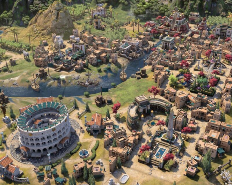 Kolorowe miasto z gry strategicznej, pełne różnorodnych budynków. Widać rzymskie koloseum, świątynie, domy i targowiska. Przez środek płynie rzeka z mostami i łodziami, a wokół rosną drzewa i palmy.