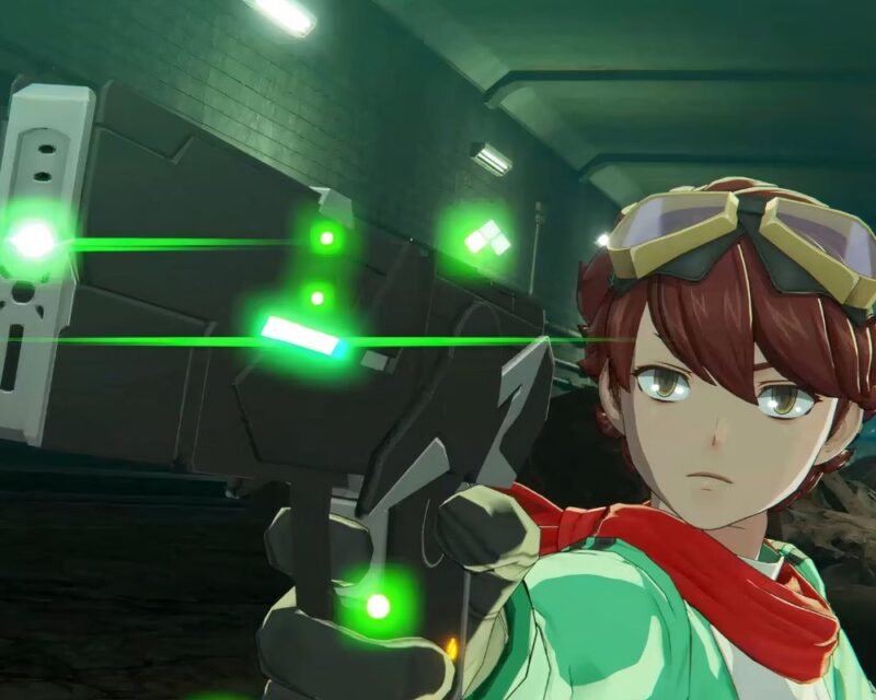 Chłopak w futurystycznym ubraniu celuje z laserowego pistoletu. W tle korytarz oświetlony zielonym światłem.