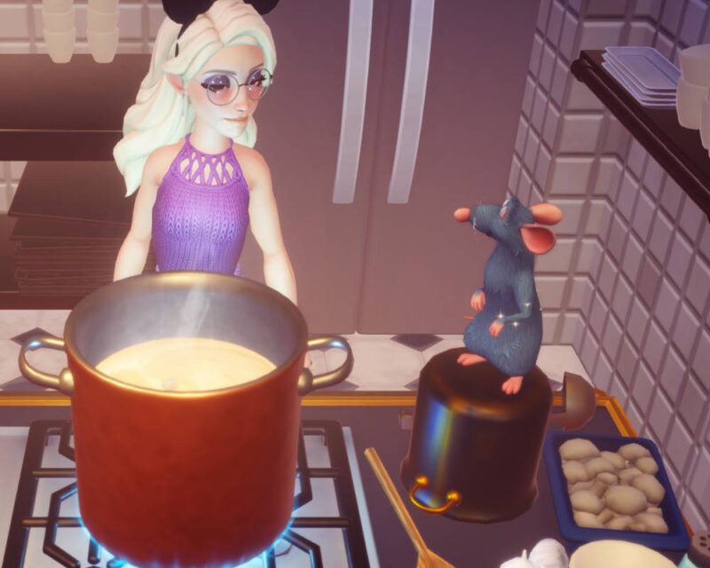 Na obrazku znajduje się postać z blond włosami w opasce z uszami Myszki Miki. Przed postacią znajduje się garnek z zupą. Obok garnka, na innym garnku stoi szczurek Remy z bajki Ratatuj i spogląda na blond dziewczynę.