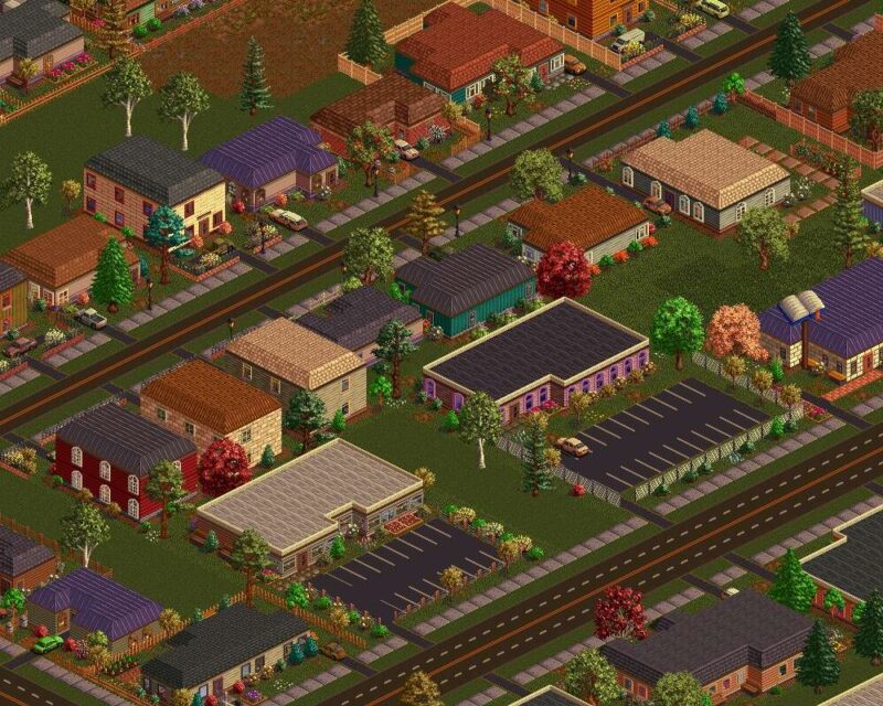 Grafika z gry **Metropolis (1998)** przedstawiająca izometryczny widok na niewielkie osiedle mieszkalne. Widać tu domy jednorodzinne otoczone ogródkami, drzewa, chodniki oraz drogi z zaparkowanymi samochodami. Na pierwszym planie znajdują się dwa większe budynki – jeden z parkingiem, przypominający sklep lub lokal usługowy. Całość utrzymana jest w stylu pixel art, charakterystycznym dla gier z lat 90.
