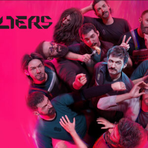 The Alters data premiery - grafika z logo "The Alters" na różowym tle i grupa altersów kolejno od góry: Bardzo zarośnięty i owłosiony; Z wąsem przeczesujący włosy; Ścięty na jeża, z brodą, który trzyma palec na ustach; Hipster w lenonkach i czapce; Jedzący pieroga i robiący rogi innemu; Z dłuższymi włosami i zmarszczonymi brwiami; "Główny" z wąsem, Szepczący; Grożący innemu z brodą; Poprawiający okulary; Z okularami i brodą, uspokajający grożącego.