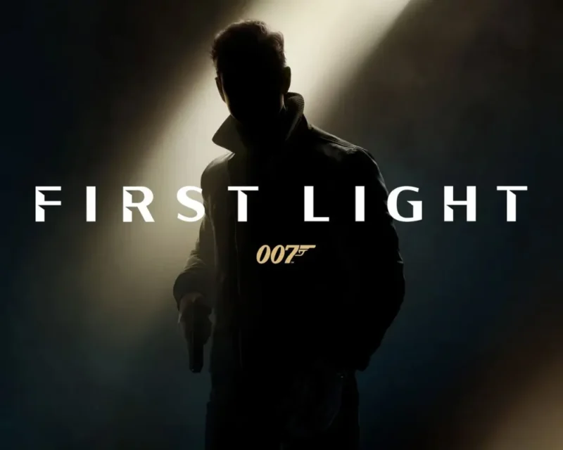 Sylwetka młodego Jamesa Bonda w półcieniu, trzymającego broń, z logo 007: First Light na ciemnym tle i snopem światła padającym z góry.